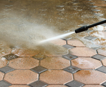 A man power washing cement - ALAC Services